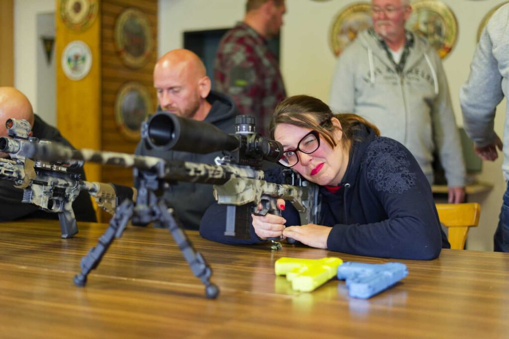 Teilnehmerin mit Gewehr Im Sitzend Anschlag